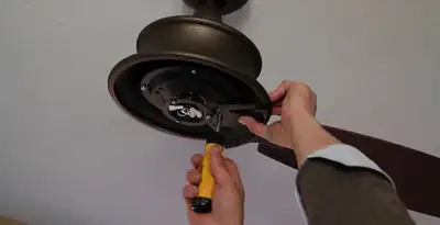 Electrician installing ceiling fan mounting bracket and fixture in Flagstaff, AZ
