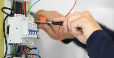 Electrician installing and adjusting circuit breakers in an electrical panel in Flagstaff, AZ