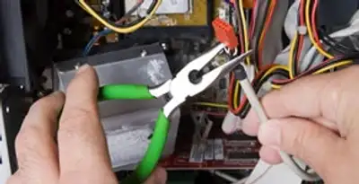 Licensed electrical contractor performing electrical repair with tools in Cornville, AZ