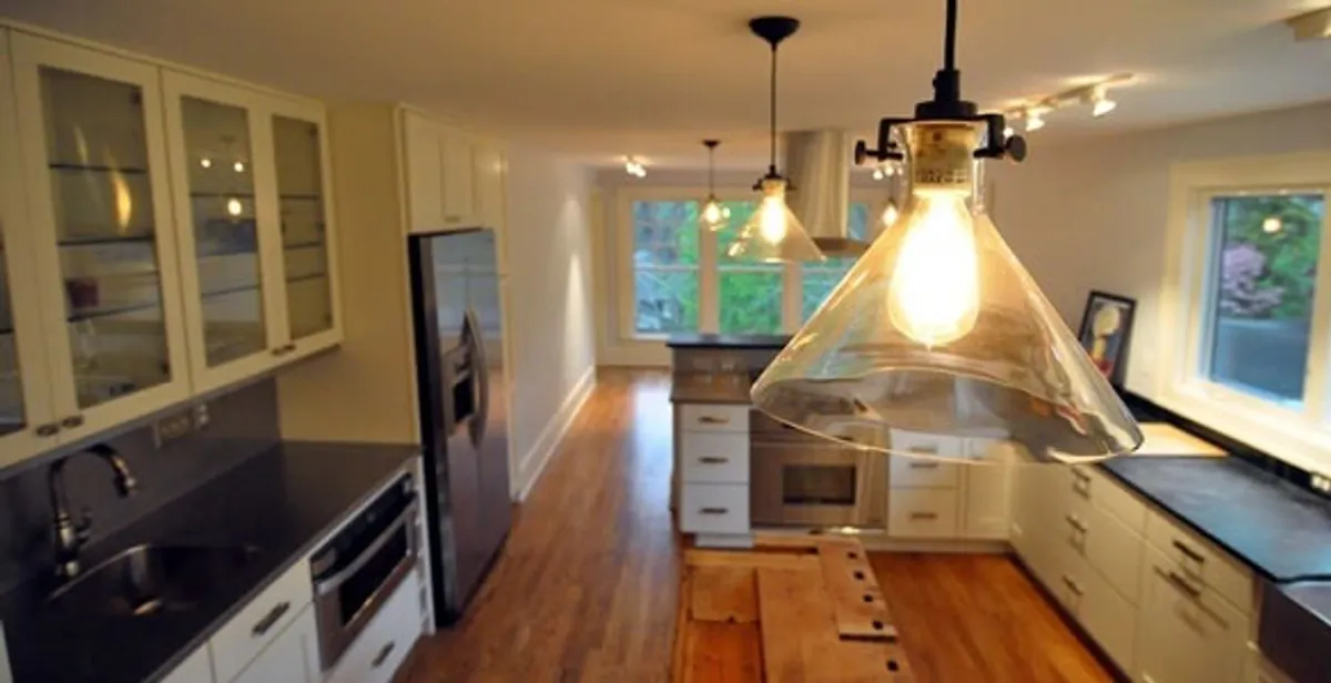 Residential electrician installing modern indoor light fixture in a home in Flagstaff, AZ