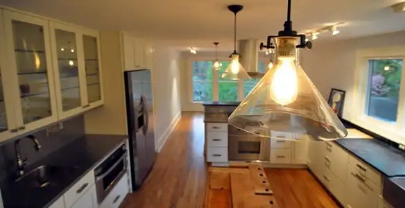 Residential electrician installing modern indoor light fixture in a home in Flagstaff, AZ
